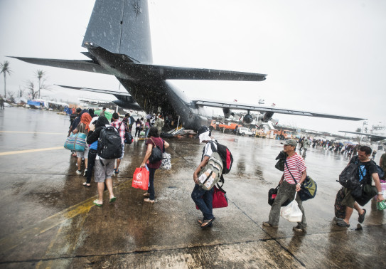 Typhoon Haiyan survivors walk toward the ramp of a RNZAF C-130H(NZ) Hercules in Tacloban, Philippines