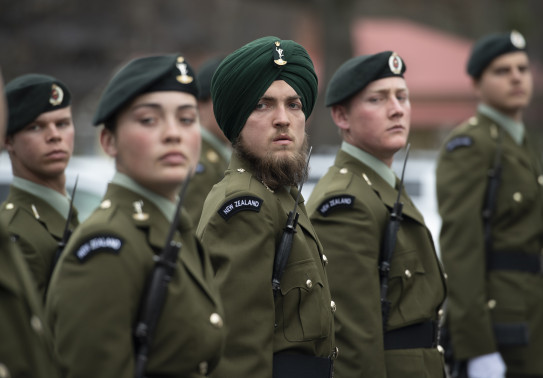 New Zealand Army soldiers in formation. The soldiers have a serious look on their face. 