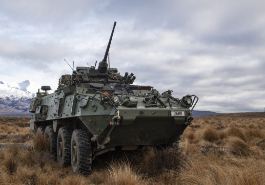 A New Zealand Army Light Armoured Vehicle (NZLAV) on the tussock grass in the Waiouru Military Training Area. In the background you can see a snow-capped Mt Ruapehu
