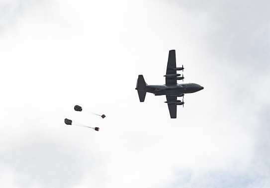 Cargo is dropped out the back of our Hurcules aircraft above the drop zone on a cloudy day over Base Ohakea.
