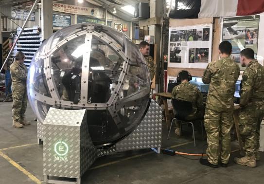 NZ Army soldiers gather around the zorb-like NOVA driving simulation technology