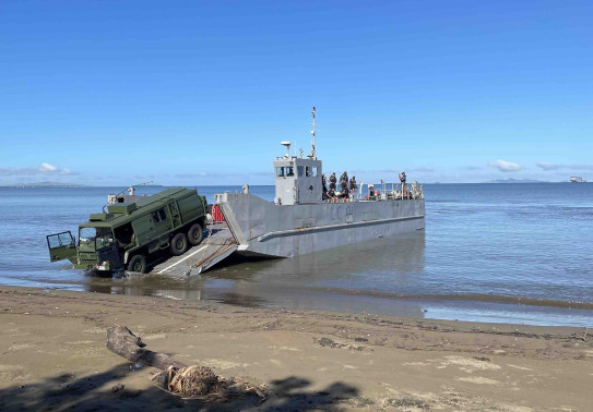 A Pinzgauer vehicle drives off a landing craft on to Lomolomo during Operation Mahi Tah