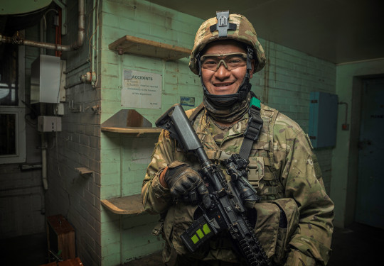 Corporal Nori Lee smiles at the camera, fully equipped in operational gear.