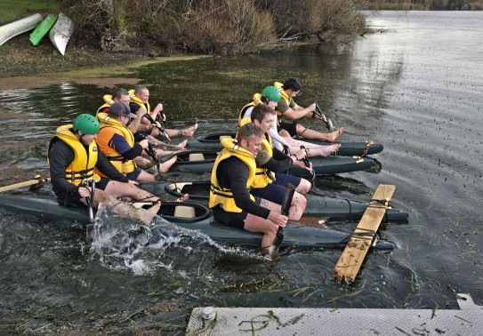 Two groups row across the lake