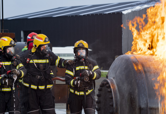 Air Force firefighters all geared up with breathing apparatus prepare to extinguish a fire