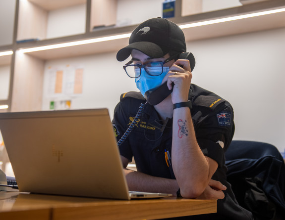 A Royal New Zealand Navy sailor on the phone while wearing a mask at the Holiday Inn, a Managed Isolation Facilty