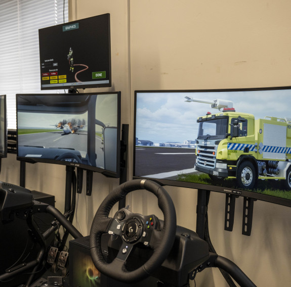 The set-up consists of three pods, each including a gaming chair, steering wheel set and a screen.