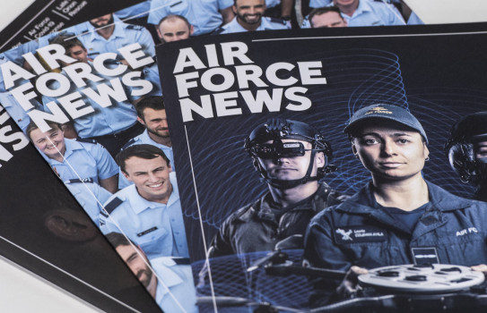 Three editions of Air Force News stacked a table 