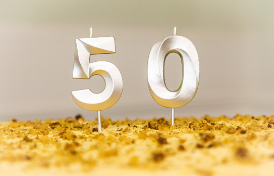 The numbers '50' as candles on top of a yellow cake.