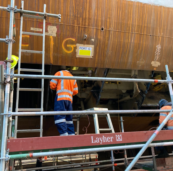 Bilge keels and shell plating being inserted into HMNZS Te Kaha's hull.