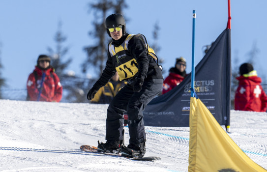 RNZAF Medic Corporal Kelly Sunnex hits the snow in Whistler on a snowboard on a bright sunny day.