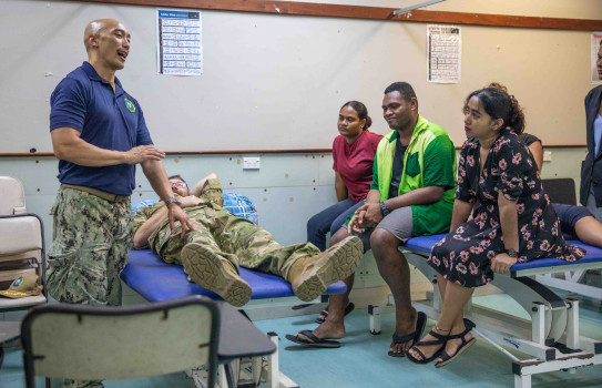 The US Navy’s Lieutenant Commander Yui Wong demonstrates physical therapy on Royal New Zealand Navy Captain John Beadsmoore to students of Fiji National University (Photo credit: US Navy Mass Communication Specialist 2nd Class Megan Alexander)